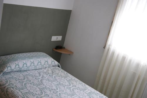 1 dormitorio con cama, cortina y ventana en Gran Vía, en Lugo