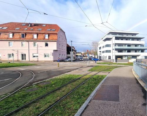 an empty street with a building and train tracks at Le frontalier appart in Saint-Louis