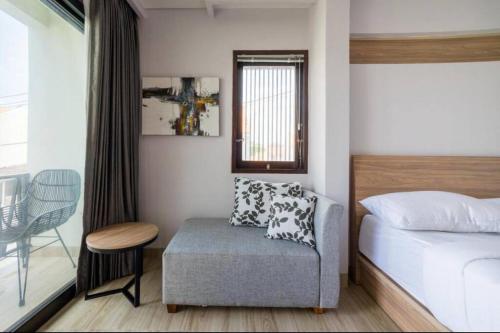 a bedroom with a bed and a chair and a table at Comfortable Villa in Quiet Area in Nusa Dua