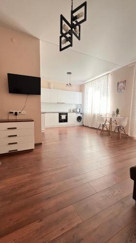 een grote woonkamer met een hardhouten vloer bij Жилой комплекс Ирина in Pavlodar