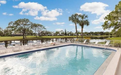 einen Pool mit Stühlen und einen Golfplatz in der Unterkunft Lake View Meadows Condo in Sarasota