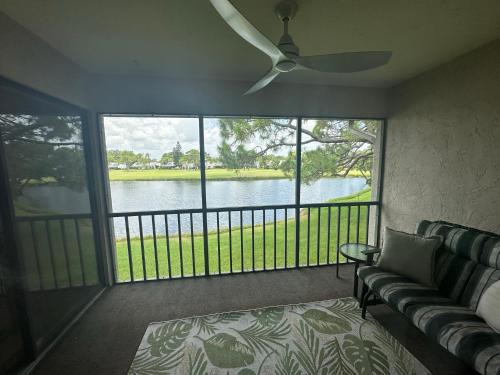 eine abgeschirmte Veranda mit einem Sofa und einem Deckenventilator in der Unterkunft Lake View Meadows Condo in Sarasota