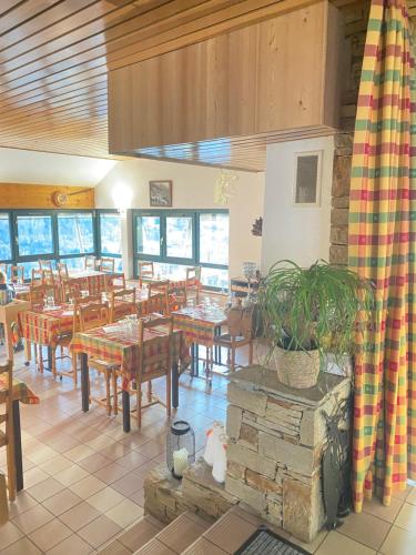 a restaurant with tables and chairs and a potted plant at Auberge le bois du cornet in La Forclaz