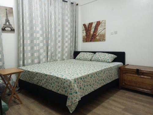 um pequeno quarto com uma cama e uma mesa em Haven Apartment em Mombasa