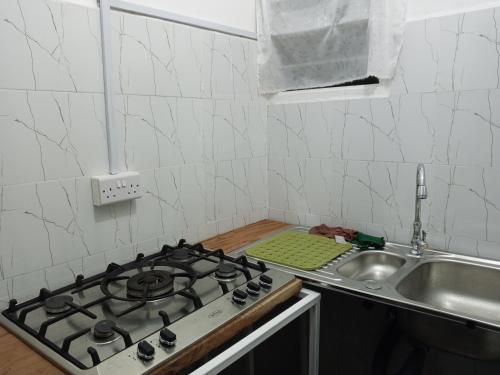 uma cozinha com fogão forno ao lado de um lavatório em Haven Apartment em Mombasa