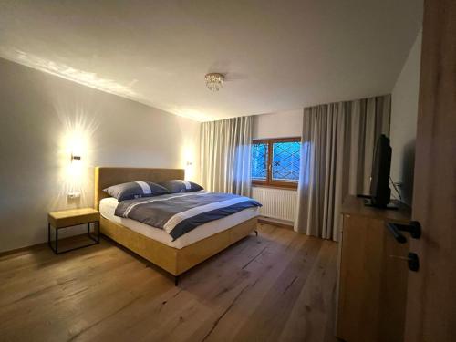 ein Schlafzimmer mit einem Bett und einem TV in der Unterkunft Apartment Lothse Shar in Dölsach