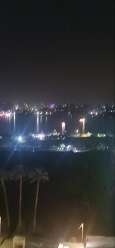 uma vista para uma cidade à noite com luzes em شقه بكورنيش النيل em Al Ma‘şarah
