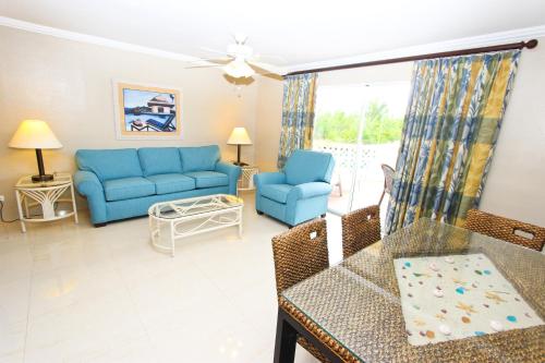 a living room with blue couches and a table at Ocean Reef Yacht Club & Resort in Freeport