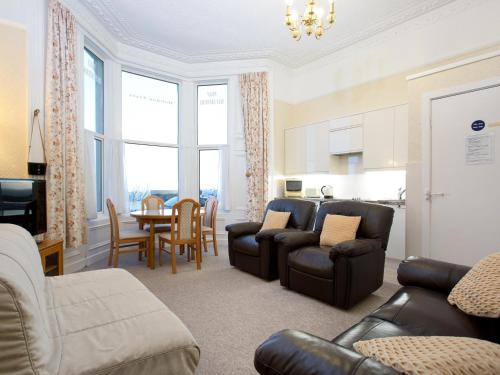 a living room with a couch and chairs and a table at Seafront Apartments in North Shields