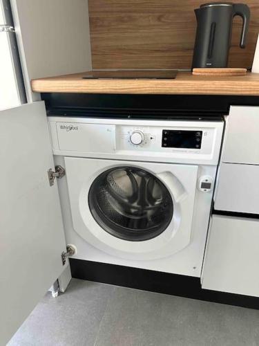 a kitchen with a washing machine under a counter at Cozy apartment in a new building apartment 3 in Piraeus