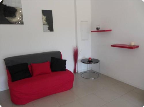 - un canapé rouge dans une chambre avec une table dans l'établissement Gîte au coeur d'une oliveraie, à Sartène