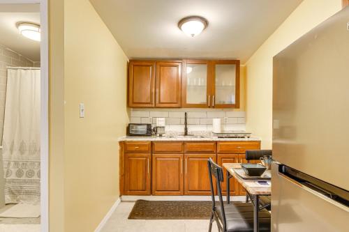 a kitchen with wooden cabinets and a table with chairs at Cozy Poughkeepsie Hideaway Near Hudson River! in Poughkeepsie