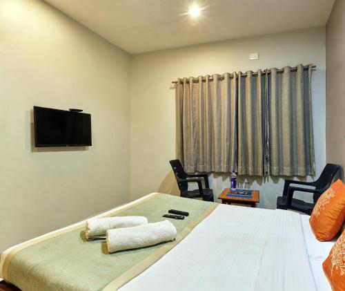 a bedroom with a bed with two towels on it at Hotel Popillon, Kolhapur in Kolhapur