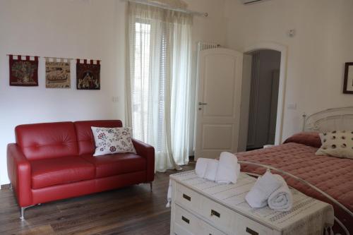 a bedroom with a bed and a red couch at Terrazza Romanelli Suites in Bitonto