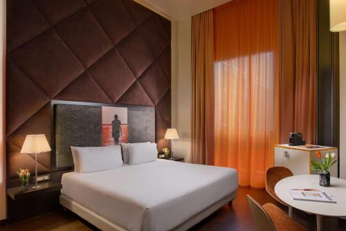 a hotel room with a bed and a table at Nhow Milan in Milan