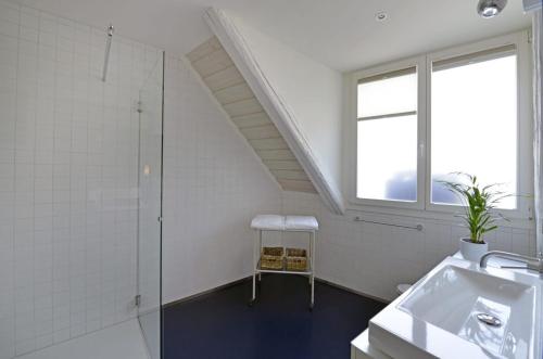 baño con lavabo, ducha y ventana en L'Eau Forte - maison d'hôtes en Saint-Blaise