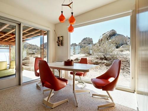 uma sala de jantar com uma mesa e cadeiras vermelhas em Marmol Radziner's Modernist Cabin - Joshua Tree em Joshua Tree