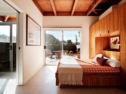 um quarto com uma cama e uma porta de vidro deslizante em Marmol Radziner's Modernist Cabin - Joshua Tree em Joshua Tree