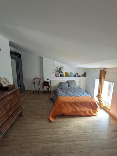 une chambre avec un lit avec une couverture orange dans l'établissement La maison Matthieu, à Bédoin
