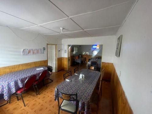 Hostal Las Ñipas في كالاما: غرفة طعام فيها طاولتين وكراسي