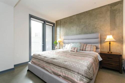 Un dormitorio con una cama grande y una ventana grande. en Cozy 3bed Condo with balcony & a rooftop pool, en Los Ángeles