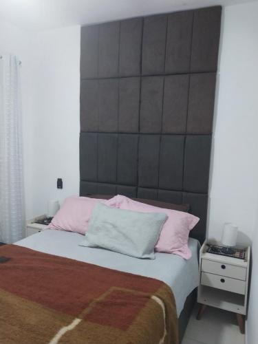 ein Schlafzimmer mit einem großen Bett mit rosa Kissen in der Unterkunft Residencial Innovare 1 in Praia Grande