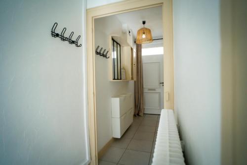 a hallway with a bathroom with a sink and a mirror at La Jeannette - séjour haut de gamme tout inclus - maison avec terrasse et lit Emma 160 dans un quartier calme proche gare in Châteauroux