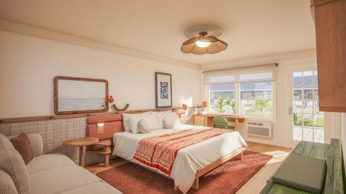 a bedroom with a bed and a couch and a mirror at Beachside on Nantucket in Nantucket