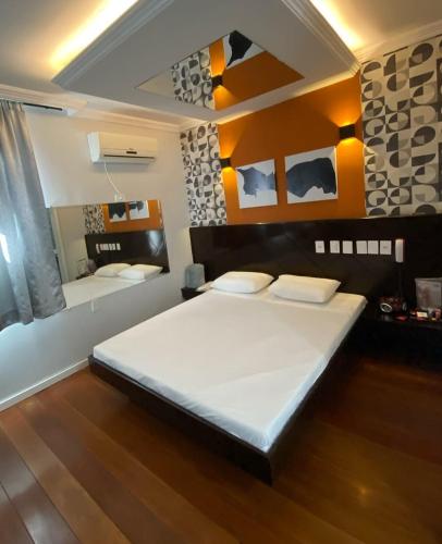 1 dormitorio con 1 cama grande y espejo en Motel Status (only adults) en Pato Branco