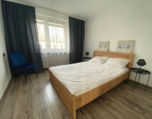 ein Schlafzimmer mit einem großen Bett und einem großen Fenster in der Unterkunft Jasnogórska in Częstochowa