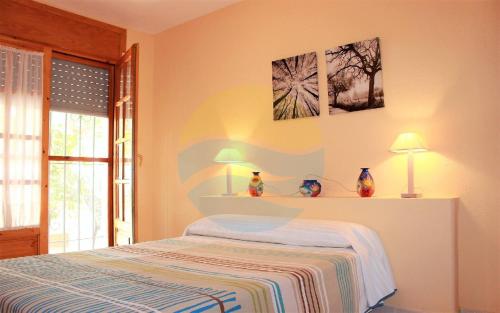 デルテブレにあるPagall - Casa rural con piscina privada y cerca la playa de Riumar - Deltavacacionesのベッドルーム1室(ランプ2つ付)