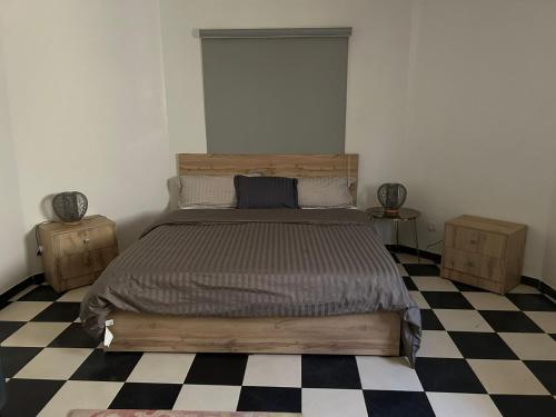 a bedroom with a bed and a checkered floor at ARABESK in Nouakchott