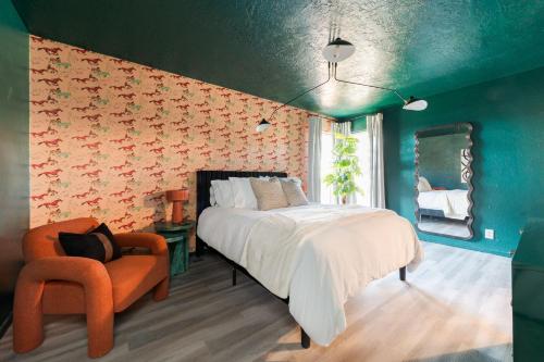 1 dormitorio con 1 cama y 1 silla naranja en The Lounge Off Lindsay en Norman