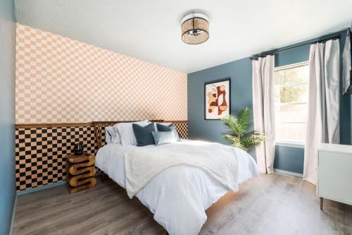 a bedroom with a bed with a checkered wall at Minutes To Ou Stadium Fire Pit Grill 3bd in Norman