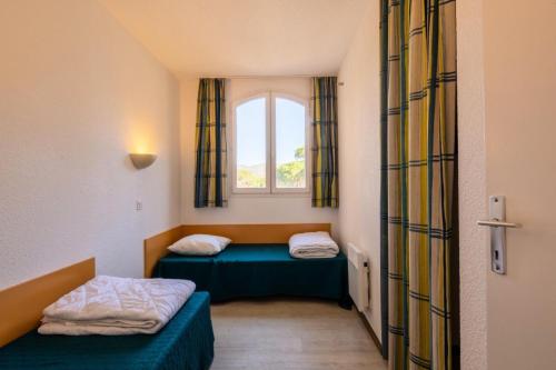 deux lits dans une petite pièce avec une fenêtre dans l'établissement Résidence Saint-Raphaël Valescure - maeva Home - Appartement 3 Pièces 6 Personnes - Sélection MAE-1375, à Valescure