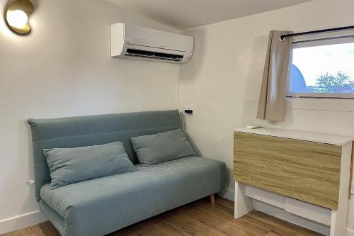 un sofá en una habitación pequeña con ventana en Atypical apartment - near garden, en Montpellier