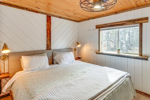 a bedroom with a bed in a room with a window at Waterfront Duluth Cabin with Deck and River View! in Duluth