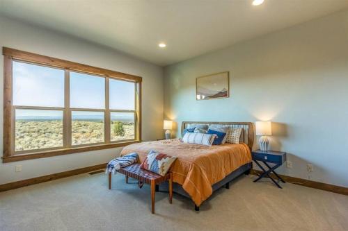 1 dormitorio con cama y ventana grande en Luxurious Home Beautiful Views Family Friendly, en Powell Butte