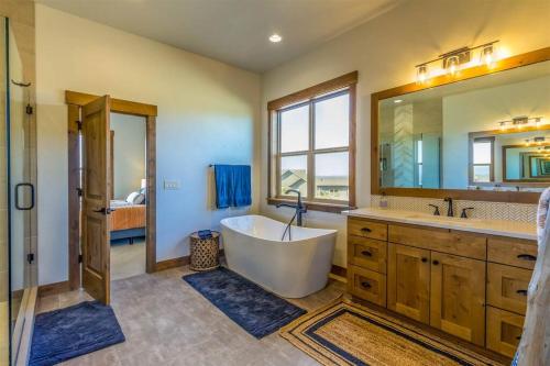 baño con bañera y espejo grande en Luxurious Home Beautiful Views Family Friendly, en Powell Butte
