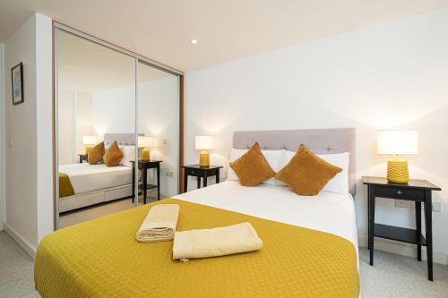 1 dormitorio con 1 cama grande con manta amarilla en Stay at Whitfield Street en Londres