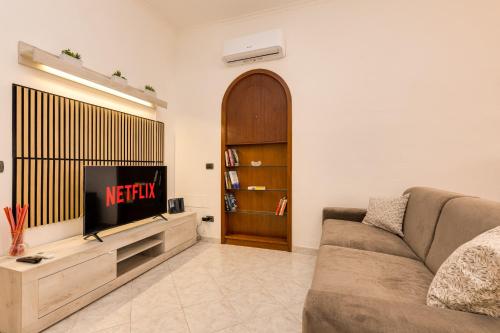salon z kanapą i telewizorem w obiekcie La Casetta di Naty w Rzymie