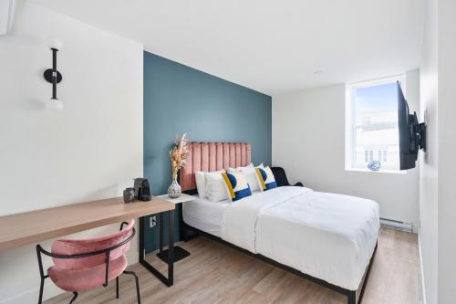 een slaapkamer met een bed en een bureau bij Clouds Boutique Hotel in Montreal