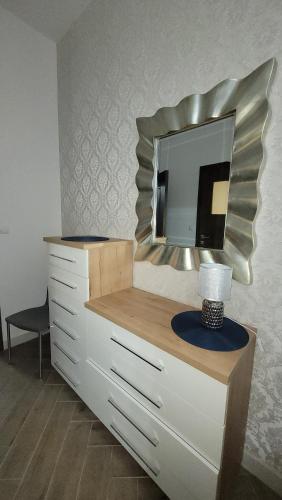 a dresser with a mirror on top of it at Apartament Jaracza 28 nr 6 in Słupsk