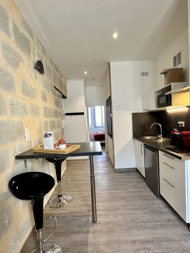 - une cuisine avec une table et un mur en pierre dans l'établissement Charmant studio hyper centre, à Angers
