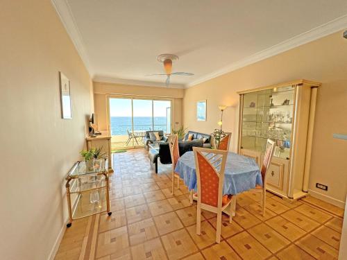 - un salon avec une table et une vue sur l'océan dans l'établissement Cosy Sea Front Apartment Nice France, à Nice