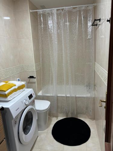 a bathroom with a washing machine and a toilet at APARTAMENTO DE AMY CON VISTA AL MAR 2 in Huelva