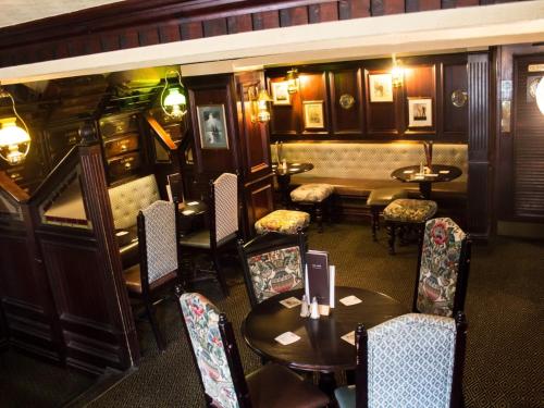 un restaurante con mesas y sillas en una habitación en The Ship en Chelmsford