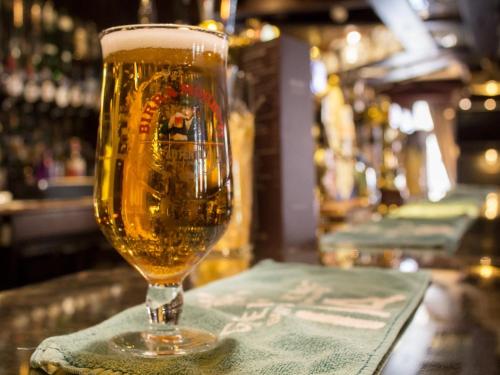 a glass of beer sitting on top of a bar at The Ship in Chelmsford