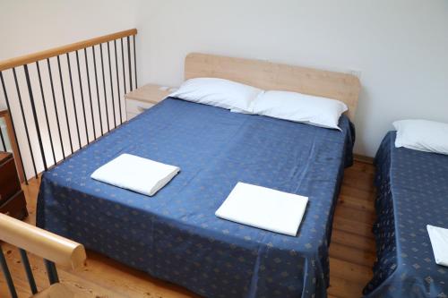 1 dormitorio con cama azul y almohadas blancas en Borgo Coricama, en Maniago
