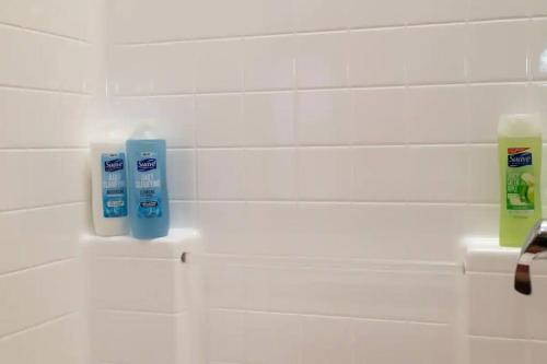 ein Badezimmer mit zwei Flaschen Zahnbürsten an der Wand in der Unterkunft Cozy 2bedApt next to Convention center/LA Live in Los Angeles